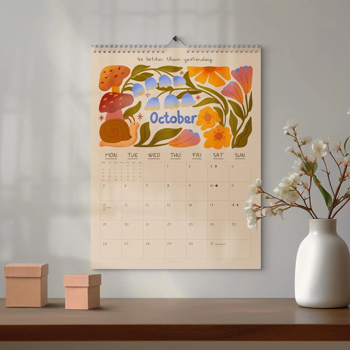 October calendar with colourful floral illustrations hanging on a wall.